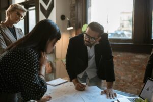 Team members engaged in a creative office brainstorming session around a desk.