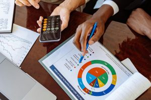 Two business professionals discussing financial documents and strategies at an office desk.