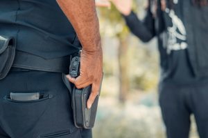 A police officer interacting with a man outdoors during the day, focusing on communication and public safety.